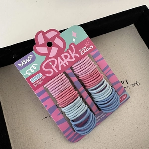 Detail view of colorful high-elastic hair ties set on card display in pink and blue tones