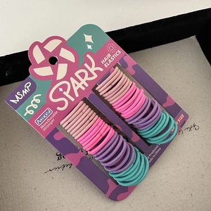 Close-up of colorful elastic hair ties set on a purple SPARK display card board