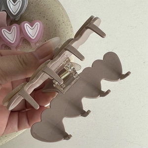 Detail of mocha frosted heart claw clip showing the durable internal metal spring