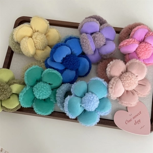 Chouchous fleurs en peluche 3D colorées présentés sur un élégant plateau en bois
