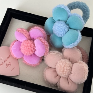 Détail d'élastiques à cheveux fleurs en peluche bleu et rose avec bordure sherpa
