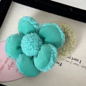 Gros plan de l'élastique fleur en peluche vert menthe montrant la texture douce