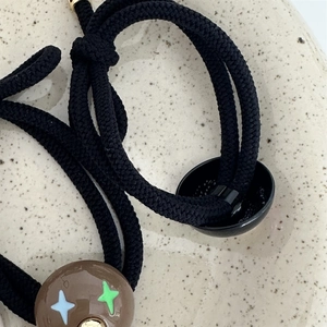 Detailed shot of durable black braided hair ties with vintage style star patterned beads