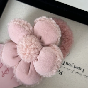 Détail d'un chouchou fleur en peluche rose avec texture douce en fausse fourrure