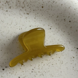 Gros plan détaillé montrant la gravure FRANCE Handmade sur une petite pince à cheveux ambre