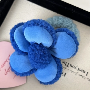 Détail d'un chouchou fleur en peluche bleue avec haute élasticité et texture douce