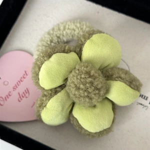 Vue détaillée de l'élastique fleur en peluche avec pétales en velours vert et texture douce
