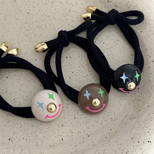 Three-piece colorful clown elastic hair ties with cartoon beads in a ceramic dish