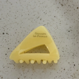 Detail shot of a triangular acetate hair claw clip with Barrette la France lettering