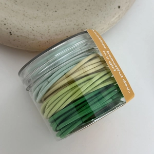 Pot met kleurrijke groene elastische haarbandjes voor meisjes in diverse tinten