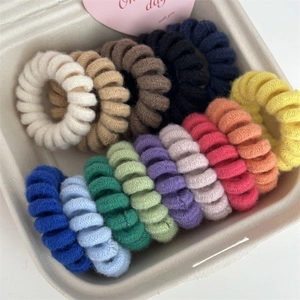 Colorful knit-wrapped spiral hair ties set displayed in a neat eco-friendly tray
