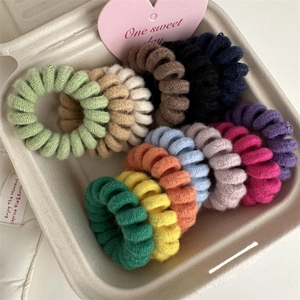 Detail of colorful knit-covered spiral hair ties in a neutral gift box with heart card