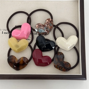 Close-up of eight heart-shaped acetic acid hair ties with France Handmade engraving