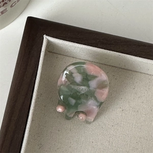 Detailopname van de handgemaakte roze marmeren mini haarklem van acetaat op display dienblad
