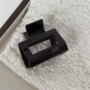 Close-up of deep brown acetate hair claw clip with golden Barrette La France text