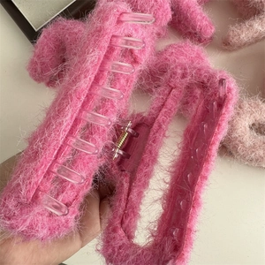 Vista ravvicinata della molletta per capelli in peluche fucsia con morbida finta pelliccia