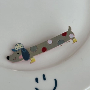 Gros plan sur la pince à cheveux teckel gris avec des pois colorés sur une assiette