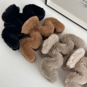 Vue détaillée de quatre pinces à cheveux en peluche ondulées en noir, caramel et beige