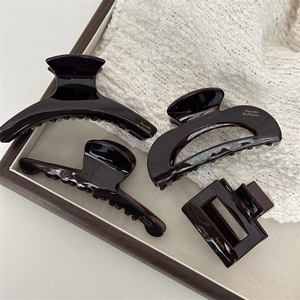 Elegant 4-piece dark coffee acetate hair claw set with gold lettering in a wooden tray
