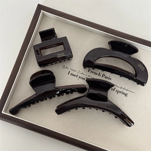 Detail view of 4 dark brown acetate hair claws with Barrette La France gold lettering
