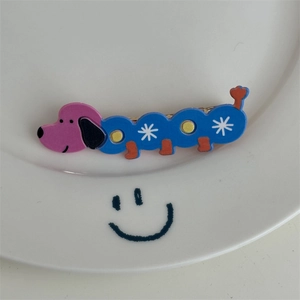 Détail d'une pince à cheveux chiot de dessin animé avec des points colorés sur plat