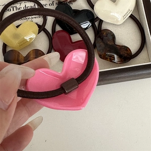 Elastic hair ties set with colorful acetate heart charms featuring golden text