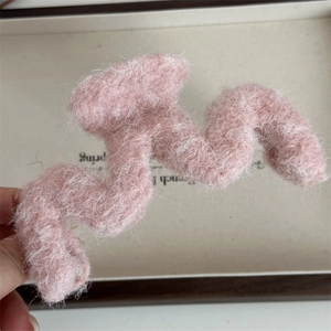 Macro di una pinza per capelli rosa chiaro in peluche con trama soffice in mohair