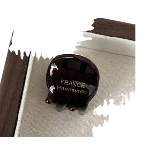 Mini bruine acetaat haarklem met gouden France Handmade logo op houten dienblad