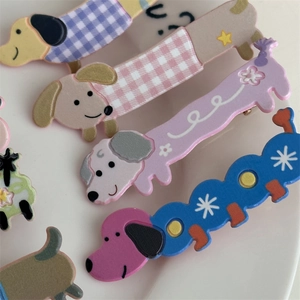 Détails de barrettes à cheveux en forme de teckel coloré sur une assiette blanche