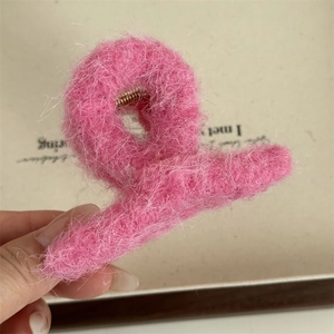 Dettaglio della clip per capelli in peluche rosa con molla in metallo dorato lucido