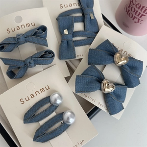 Detailansicht von Jeans-Schleifen-Haarspangen mit Perlen auf einer weißen Displaykarte