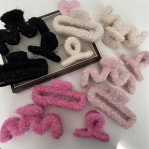 Vista dettagliata di varie pinze per capelli in peluche rosa e beige in ecopelliccia