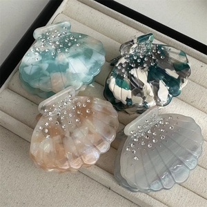 Set of four seashell claw clips in pastel colors with rhinestones and pearly finish