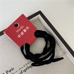 Détail d'élastiques à cheveux noirs à haute élasticité avec étiquette rouge de marque