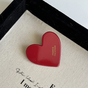 Red acrylic heart hair clip with gold France Handmade lettering on a canvas texture