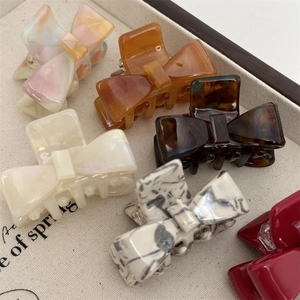 Close-up of acetic acid bow hair clips in various patterns like tortoise and pearl
