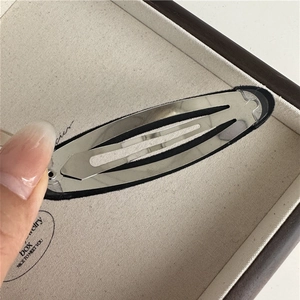 Close-up of the silver metal BB hair clip showing the back mechanism and black fabric base