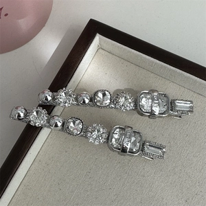 Détail de barrettes argentées avec strass scintillants dans un écrin de luxe