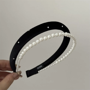 Close-up of double-layer headband set with black velvet, rhinestones and white faux pearls