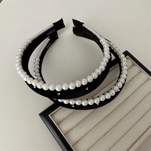 Detail of black velvet headbands with large faux pearls and sparkling rhinestones