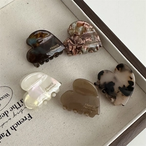 Set of five heart-shaped acetate hair claws in various elegant marble and tortoise patterns