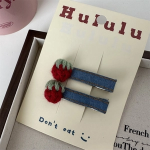 Détail de barrettes fraises au crochet faites main sur pinces BB en denim bleu pour filles
