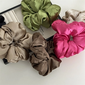 Ensemble de chouchous en satin luxueux aux couleurs vives sur un plateau élégant