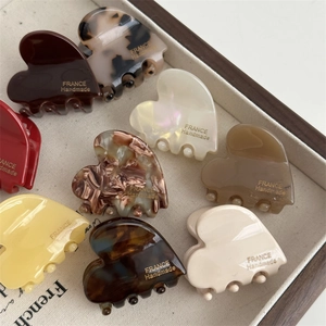 Detail view of heart-shaped acetate hair claws with premium France Handmade engraving