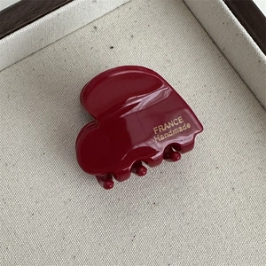 Detail of burgundy heart hair claw with France Handmade gold lettering on acetate