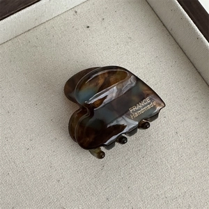 Close-up of heart-shaped tortoiseshell hair claw with gold France Handmade lettering