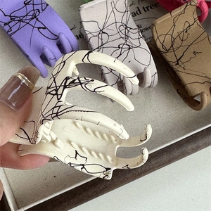 Haarklammer mit mattem Finish und abstrakten schwarzen Linien im Splatter-Ink-Design