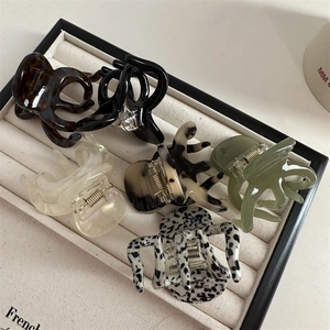 French style acetate claw clips in tortoiseshell and marble colors on a jewelry tray