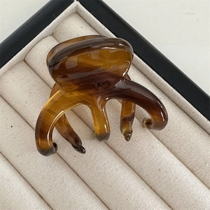 Close-up of elegant amber tortoiseshell acetate hair claw with five-teeth design