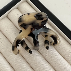 Macro shot of French acetate hair claw clip with cream tortoiseshell pattern in a box